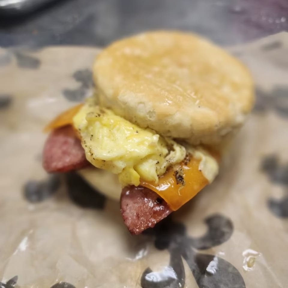 Astrid's southern breakfast biscuit with sausage, scrambled egg, and melted cheese.